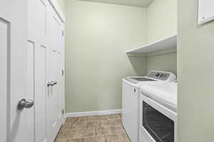 Laundry room with separate washer and dryer and baseboards