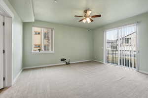 Primary bedroom suite featuring a ceiling fan, carpet flooring, and a textured ceiling