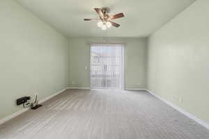 Primary bedroom suite with a spacious walk-in closet, light colored carpet, ceiling fan, and ensuite bath
