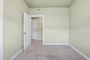 Secondary bedroom with light colored carpet and a textured ceiling