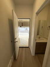Corridor featuring a sink and light wood finished floors