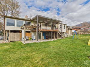 Rear view of property with a patio area, a wooden deck, a playground, and a chimney