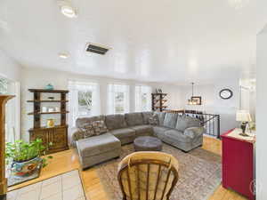 Living room with light wood-style floors and a textured ceiling