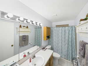 Bathroom featuring a shower with shower curtain, vanity, and light tile patterned flooring