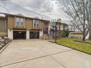 View of front of property with a front lawn, a garage, concrete driveway, and brick siding