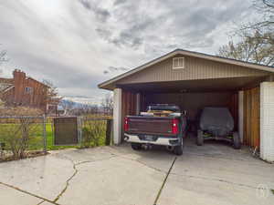 Garage/Shed North Side of home featuring a driveway, and a carport