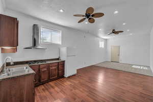 Kitchen with dark countertops, freestanding refrigerator, dark wood finish cabinets, plenty of natural light, and a textured ceiling