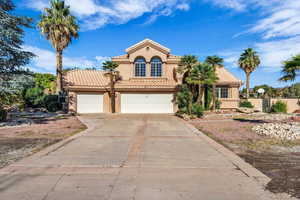 Mediterranean / spanish house featuring stucco siding, a tile roof, concrete driveway, and a garage
