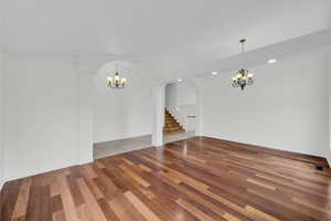Unfurnished dining area with a chandelier and wood finished floors