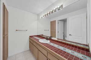 Full bath featuring vanity and light tile patterned floors
