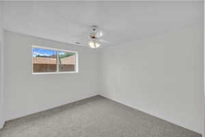 Unfurnished room featuring a ceiling fan and carpet floors