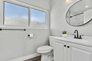 Bathroom with vanity, a shower, and dark wood-style floors