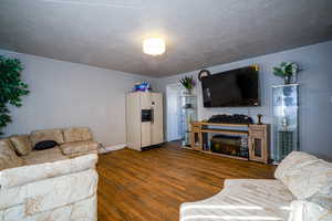 Living area with wood-type flooring and a textured ceiling
