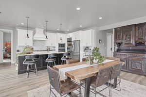 Dining area with light wood-style flooring and recessed lighting