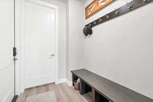 Mudroom featuring light wood-style flooring and baseboards