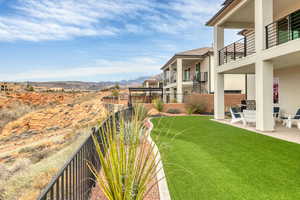 Fenced backyard with a balcony, a mountain view, and a patio area