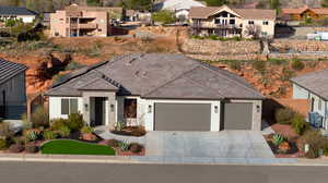 Single story home with a residential view, a garage, driveway, and solar panels