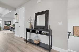 Hallway featuring light wood-style flooring and baseboards