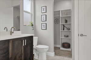 Bathroom with vanity and a walk in closet
