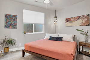 Carpeted bedroom featuring ceiling fan and baseboards