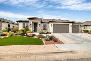 Prairie-style house featuring stucco siding, concrete driveway, a front yard, stone siding, and a garage