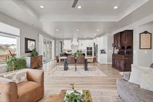 Living area with light wood finished floors and recessed lighting