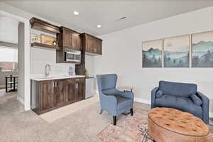 Living area featuring light colored carpet and recessed lighting