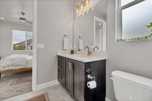 Half bathroom with vanity, ensuite bathroom, and a ceiling fan