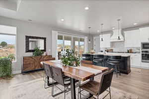 Dining room with light wood-style floors and recessed lighting