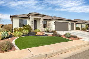 Prairie-style house featuring stucco siding, a tiled roof, driveway, and a garage