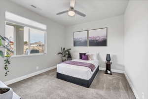 Carpeted bedroom with ceiling fan and baseboards