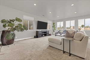 Carpeted living room featuring baseboards and recessed lighting