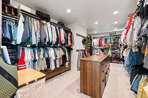 Walk in closet with light colored carpet