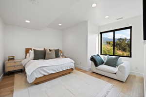 Bedroom with light wood-style flooring, recessed lighting, and a mountain view