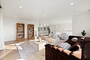 Living area with wood finished floors and recessed lighting