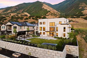 Back of house with a fenced backyard, a patio, stucco siding, and a mountain view