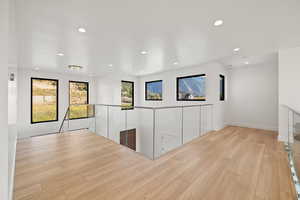 Empty room featuring light wood-style flooring and recessed lighting