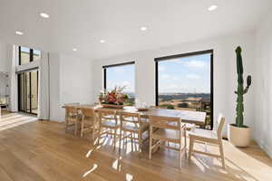Dining area with light wood-style floors and recessed lighting