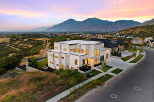 View of front facade featuring a mountain view, concrete driveway, stucco siding, and a garage