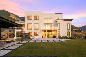Rear view of house featuring a mountain view, a patio area, a fire pit, and stucco siding