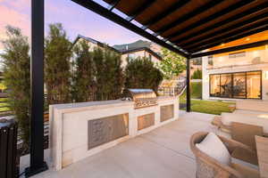 Patio terrace at dusk featuring a patio and exterior kitchen