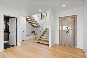 Stairway featuring wood finished floors and recessed lighting