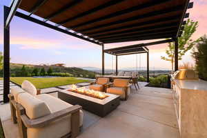 View of patio / terrace featuring an outdoor kitchen and area to lounge, a pergola, and an outdoor fire pit