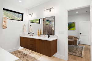 Bathroom with double vanity, recessed lighting, a shower with door, and light wood finished floors