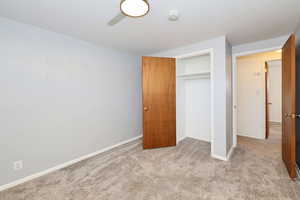 Unfurnished bedroom with light carpet and a closet