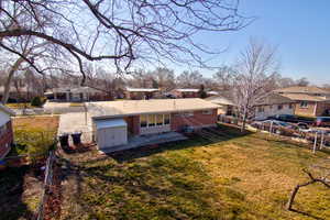 Back of house featuring a residential view, brick siding, a patio area, a storage shed, and a fenced backyard