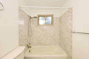 Bathroom featuring bathing tub / shower combination and toilet