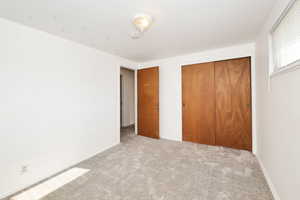 Unfurnished bedroom with carpet and a closet