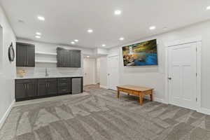 Bar featuring open shelves, light colored carpet, recessed lighting, and stainless steel fridge