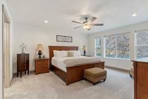 Bedroom featuring light carpet, ceiling fan, and recessed lighting